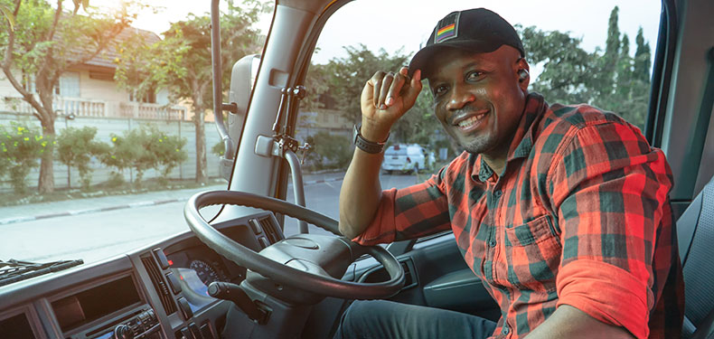 A photo of a truck driver leaning on their steering wheel.